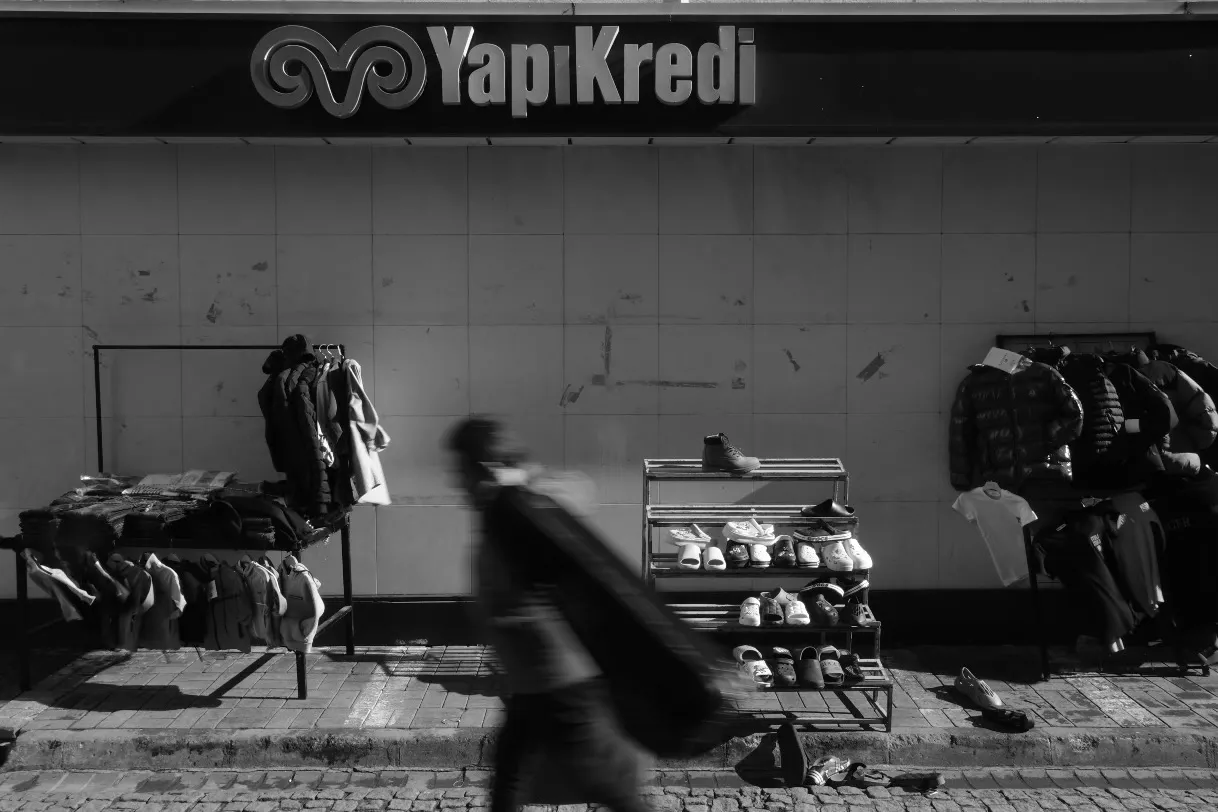 Banka şubesinin önünde kurulmuş seyyar giyim tezgâhları, önünden geçen bir kişi
